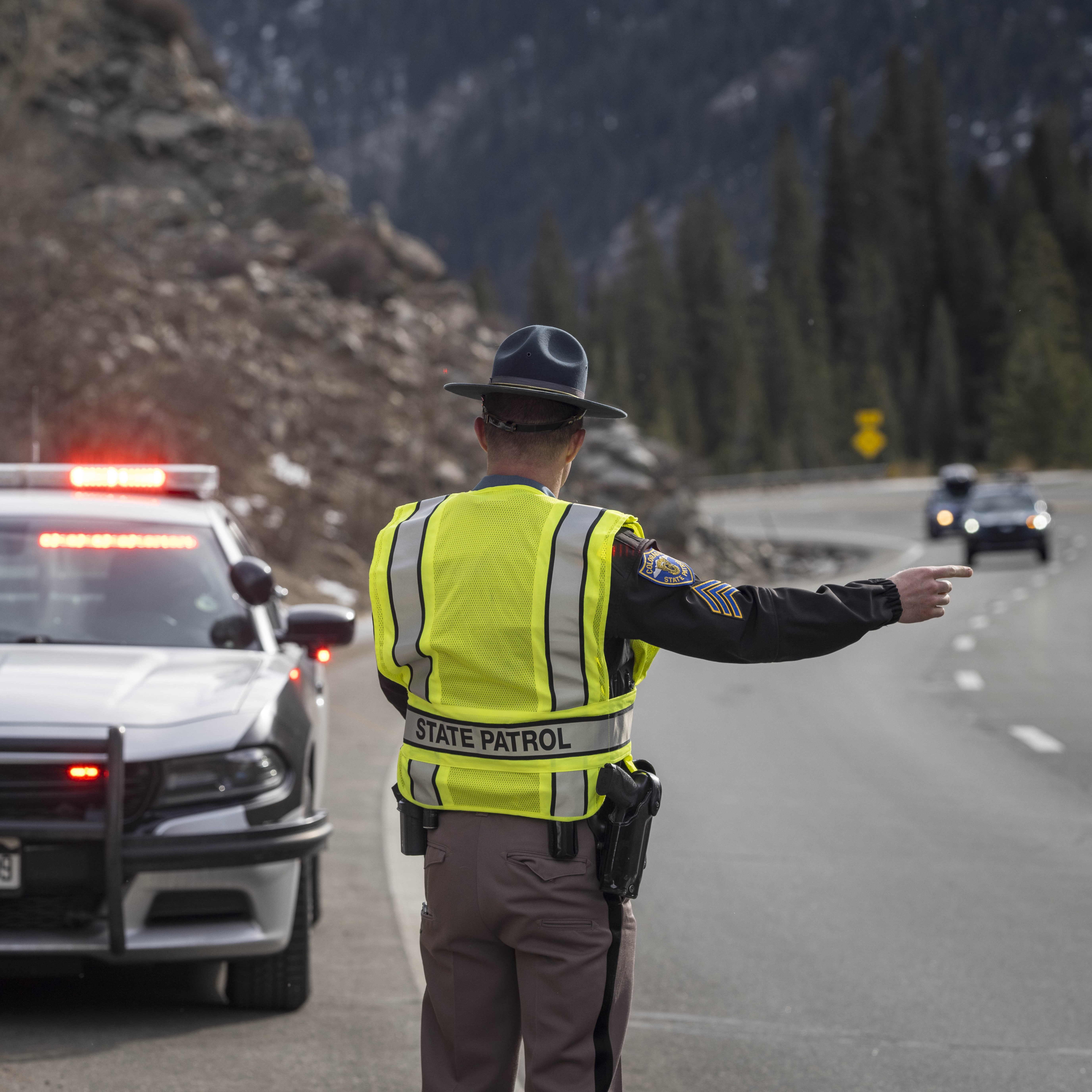 State trooper signaling for car to move over.