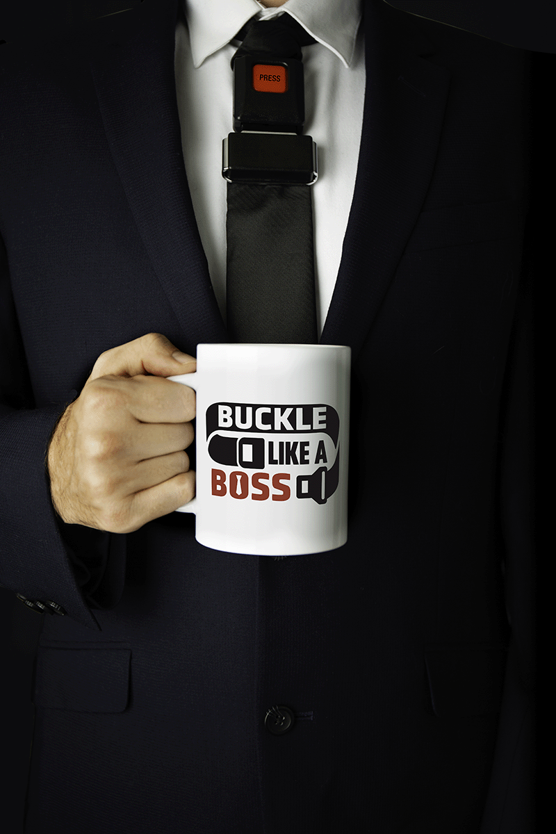 Individual in suit holding mug with a tie that looks like a seatbelt.