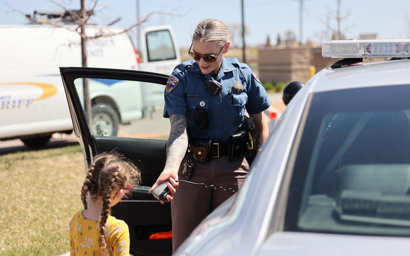 Trooper Gunst letting student speak into radio. 